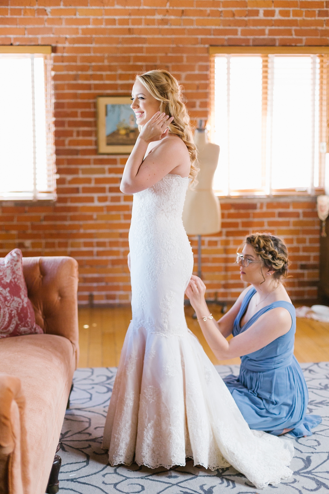 maid of honor helps bride get dressed at Carondelet House