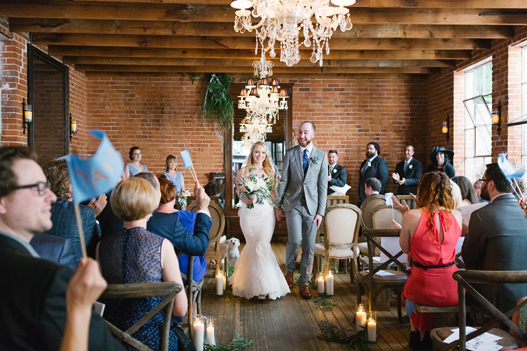 bride and groom walk happily down the aisle at carondelet house
