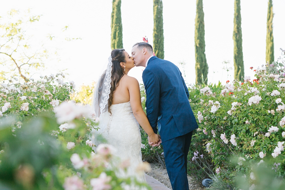 bride and groom kiss surrounded by flowers at gershon bachus vintners
