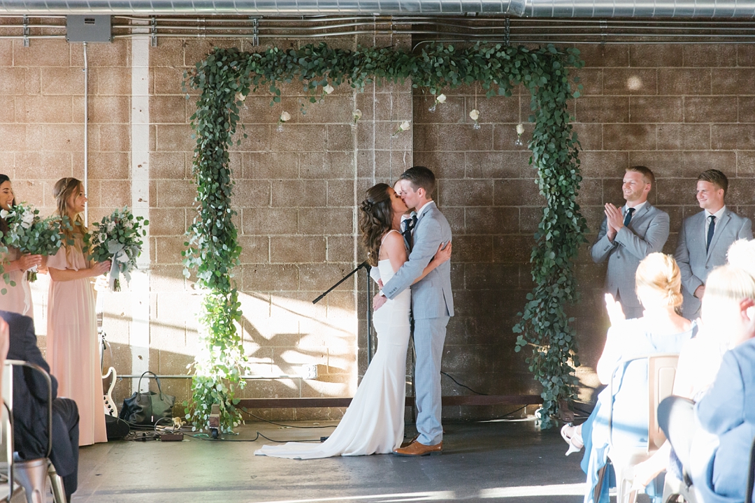 bride and groom share first kiss at smoky hollow studios