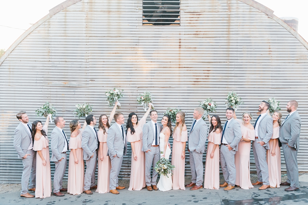 large bridal party against metal wall outside smoky hollow studios