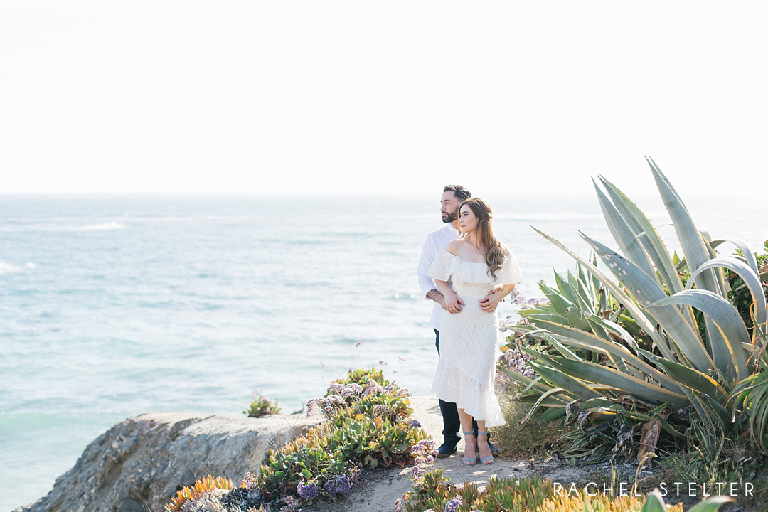 couple looks out over ocean at laguna beach engagement session