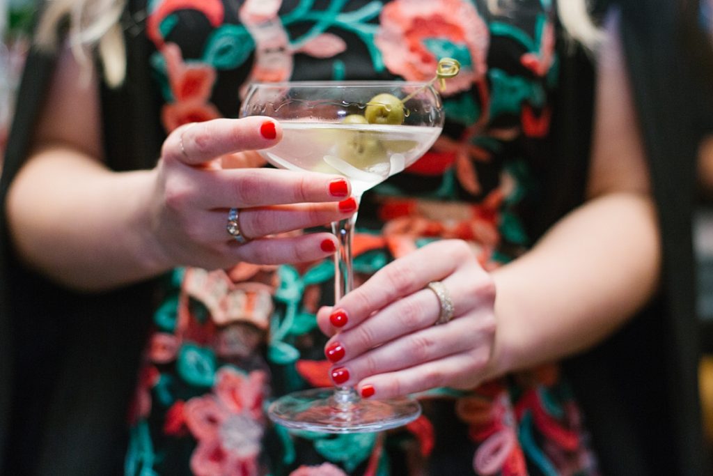 guest holds martini at smithy kitchen + bar wedding reception
