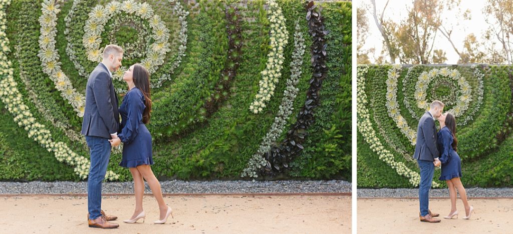 couple poses for engagement photos in front of living wall at south coast botanic garden