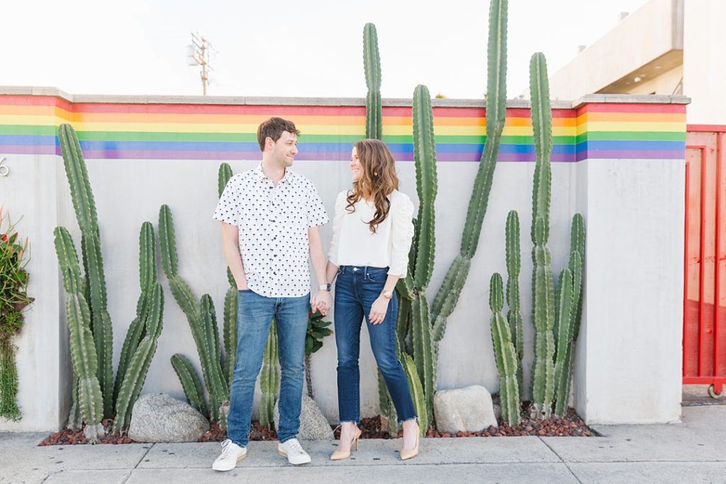 fun West Hollywood engagement session in front of cactus and rainbow wall