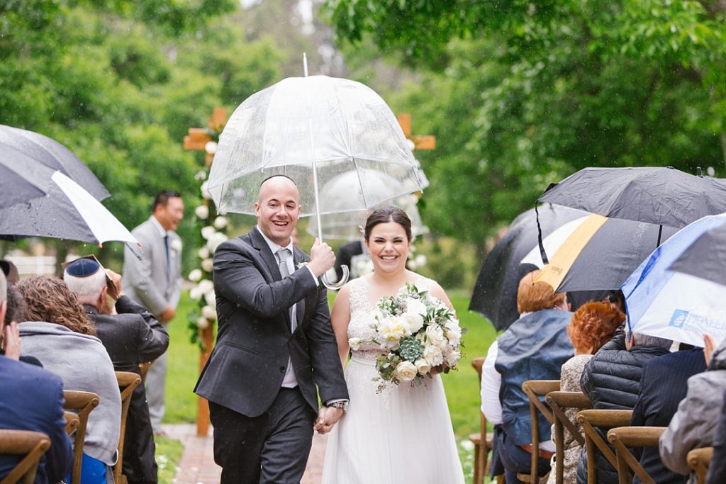 rainy southern California wedding with clear umbrella for bride and groom