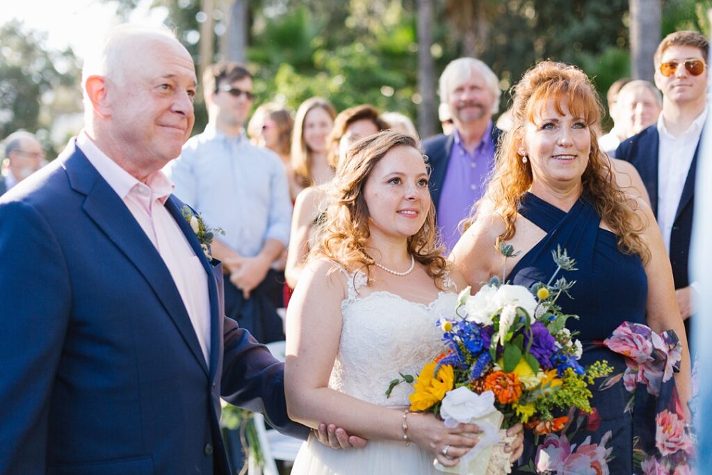 smiling parents hand off bride to her groom