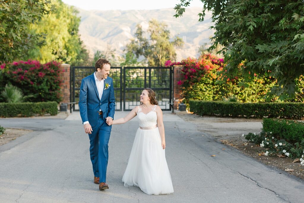 bride and groom walk main entryway at their summer Newhall Mansion wedding