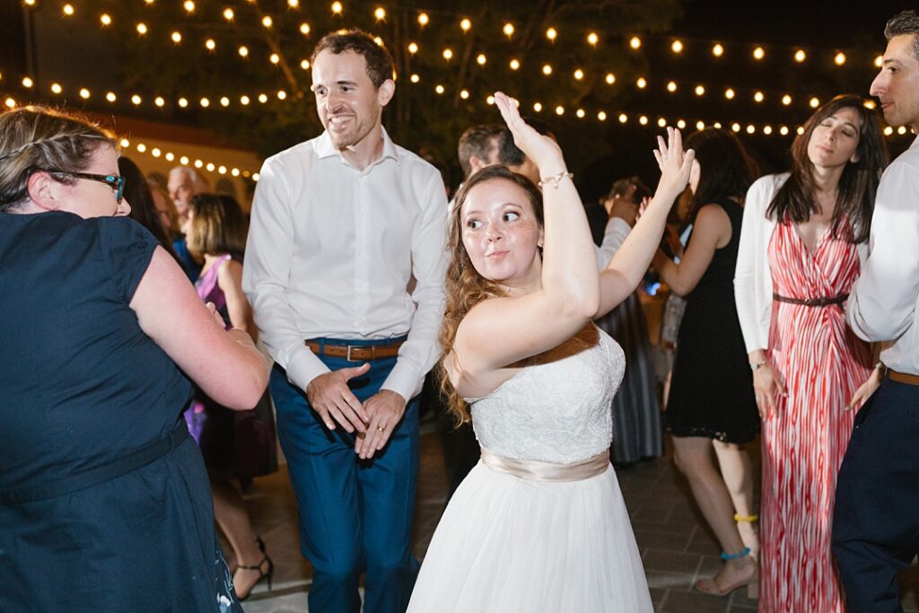 bride and groom dance under bistro lights