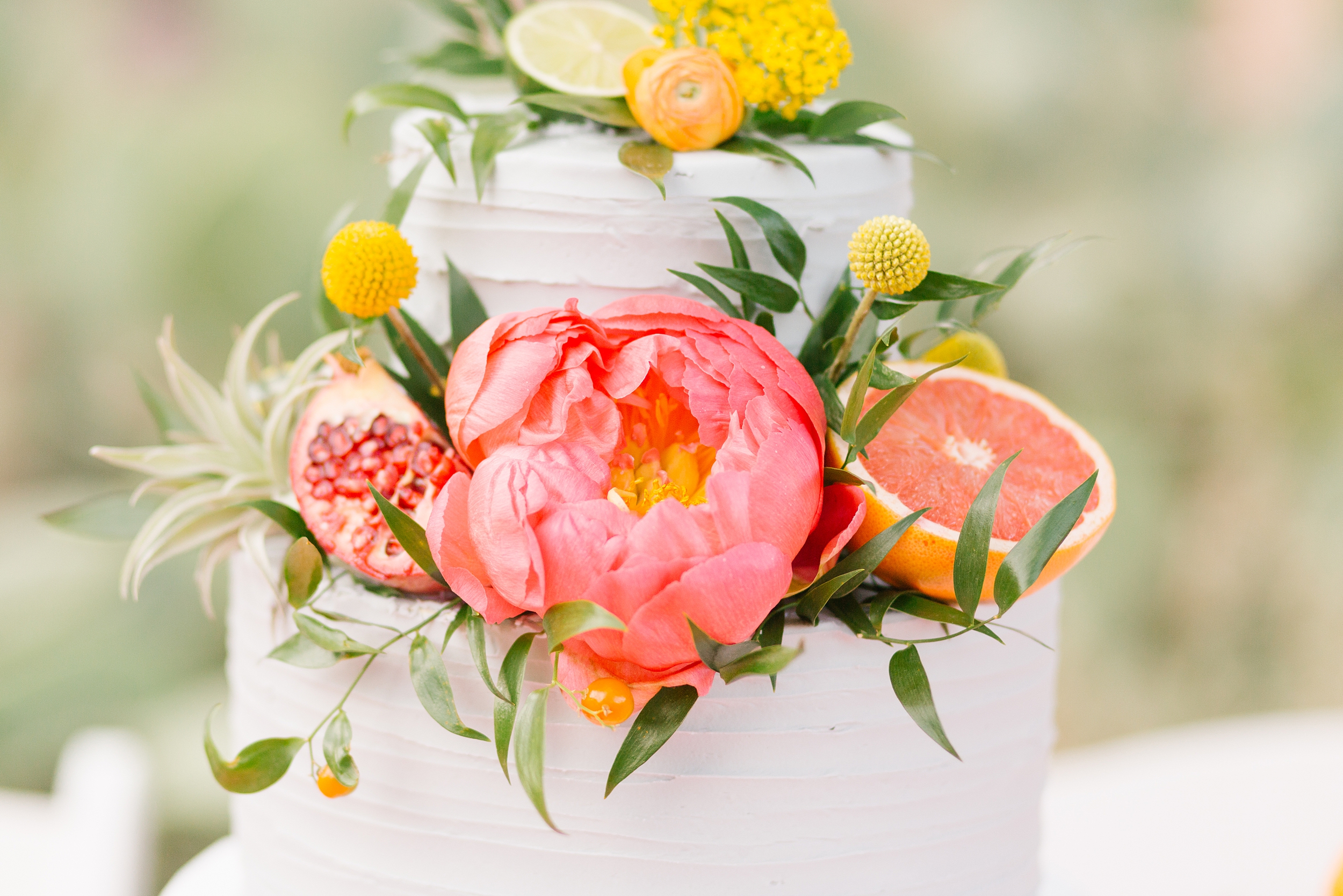 bright colored flowers, grapefruit and pomegranate on wedding cake