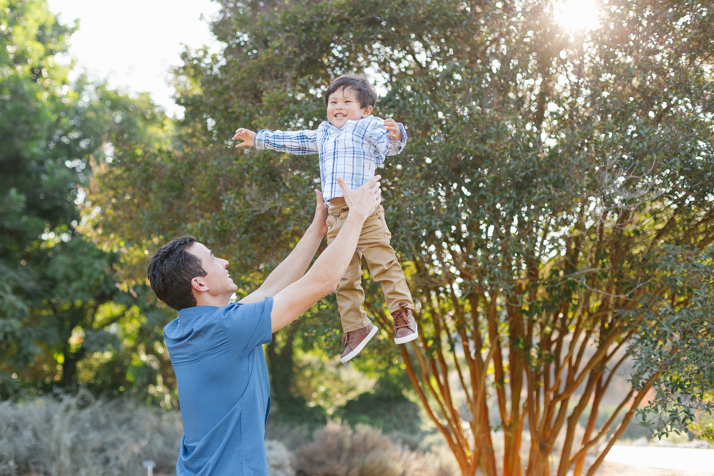 dad tosses son in air at South Coast Botanic Garden portrait session 