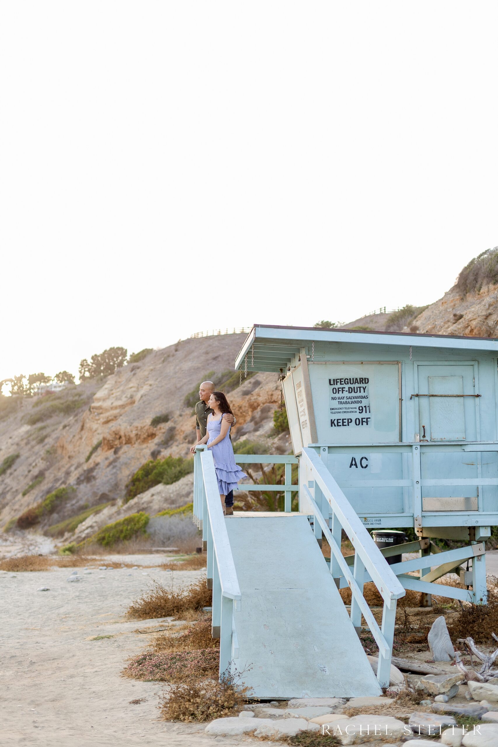 engagement photo of couple looking out at Pacific Ocean from lifeguard tower in Palos Verdes