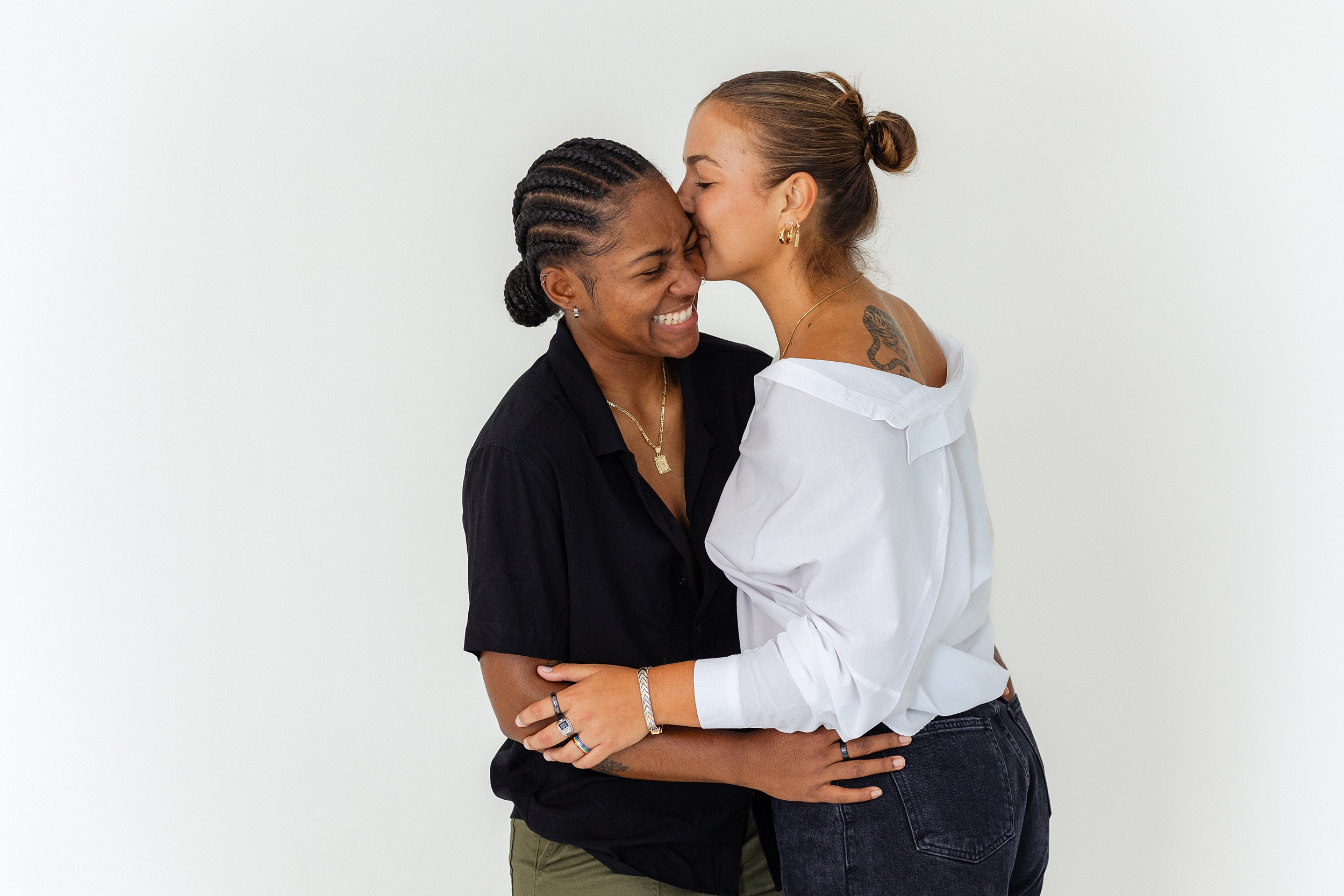 couple laughs against white background during studio session