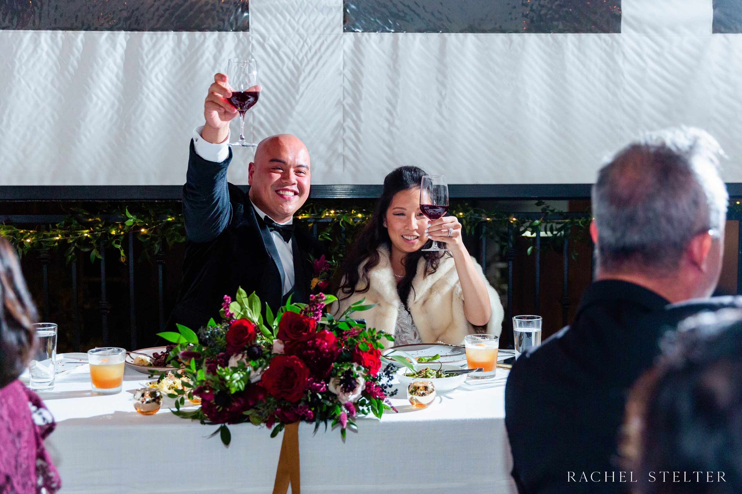 bride and groom toast red wine at their winter wedding in SoCal